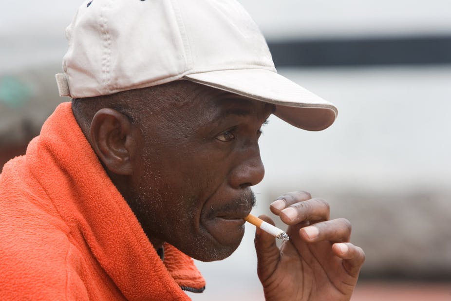 man smokes cigarette in Africa