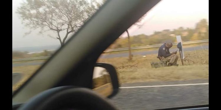 Pictures: More SAPS complacency as police officer on duty is captured hiding from responsibility and busy on WhatsApp