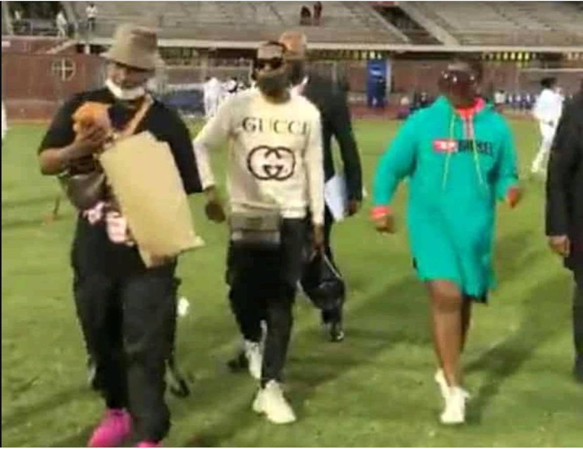 Royal AM chairman Andile Mpisane (left) and President Shauwn Mkhize (far right) attempt to give players cash on the pitch